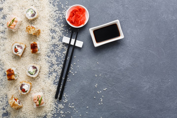 Fototapeta na wymiar Top view on set of sushi roll, maki on rustic grey and white rice background