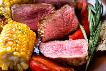 Slices of poorly fried steak with corn and vegetables