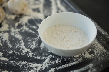 Close up of flour in bowl by dough n baking sheet