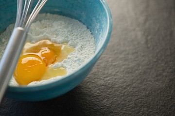 Close up of flour and egg in container