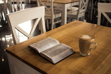 open bible and a cup of cappuccino