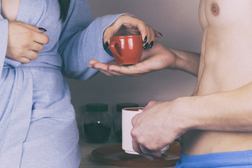 Woman and man drinking tea in the kitchen and talking