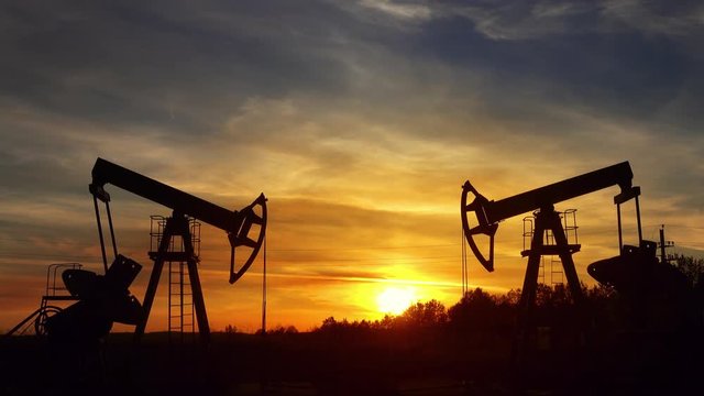 working oil pumps silhouette against sunset, 4k
