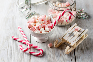 Fototapeta na wymiar Christmas cup with small marshmallows and candy canes