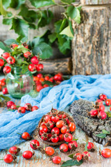 Berries of a dog rose in a bowl on a wooden table