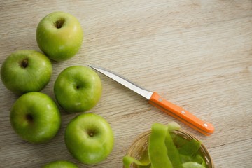 Close-up of granny smith apples by peel and kitchen knife