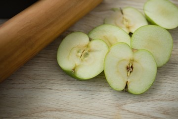 High angle view of granny smith apple slices by rolling pin