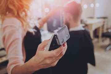 Master cuts hair and beard of men, hairdresser makes hairstyle for a young man. Hipsters