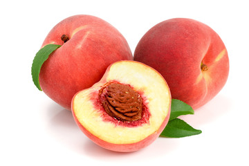 Peaches and half with green leaf isolated on white background