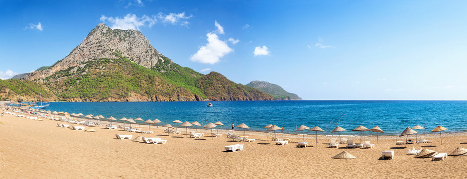 beach with umbrellas and sunbeds on the shores of the Mediterranean Sea in Turkey