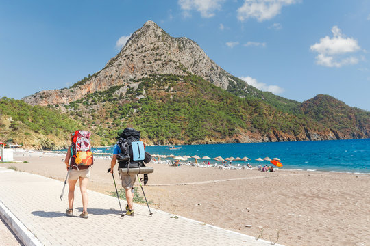 Group of hikers with backpacks walking along Lycian way near the beach in Adrasan Bay, Turkey