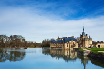 Fototapeta na wymiar Chantilly castle reflected in water of lake