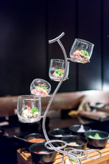 Japanese fusion gourmet for cocktail party in glass candleholders with stands.