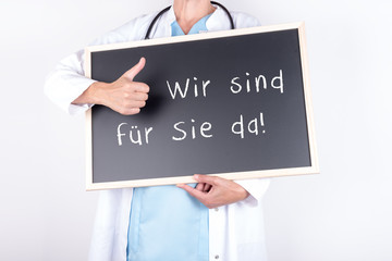 Arzt mit Schild wir sind für Sie da