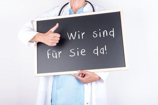 Arzt mit Schild wir sind f&uuml;r Sie da