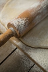 Close up of rolling pin on rolled dough over cutting board