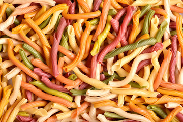 A background of colorful pasta textures close-up. Colored natural pasta. Macaroni of Italian quality.