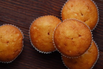 Delicious fresh cupcakes with cream on a wooden table 