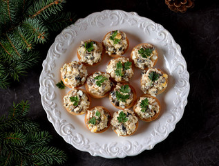 Snack tartlets with boiled chicken, fried mushrooms and onion with egg and mayonnaise.