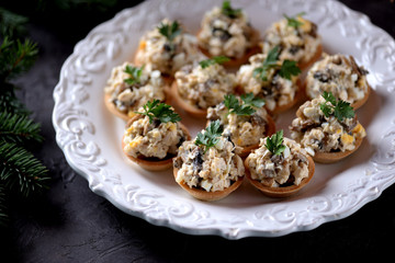 Snack tartlets with boiled chicken, fried mushrooms and onion with egg and mayonnaise.