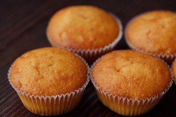 Delicious fresh cupcakes with cream on a wooden table 