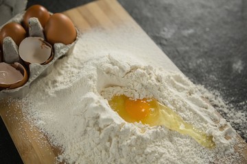 High angle view of egg yolk in flour ny carton on cutting board