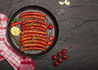 Wiener Sausages in a pan on black background with copy space