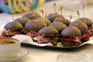 Black hamburger juicy beef burger with  onion on the plate