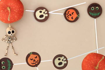 Halloween. Frame with chocolate lollipops, pumpkins and a funny skeleton