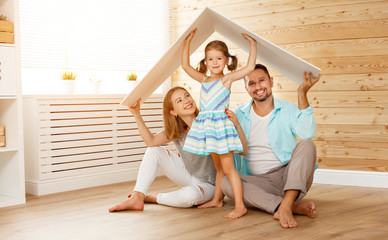 concept housing   young family. Mother father and child in new house with  roof
