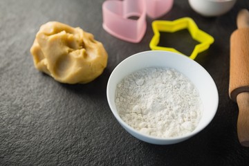 High angle view of dough and flour with pastry cutters