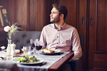 Fototapeta na wymiar Handsome man waiting at table in restaurant