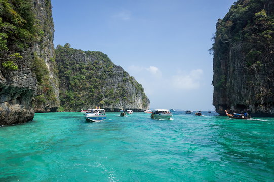 Экскурсионные лодки везут туристов по морю, между скал.