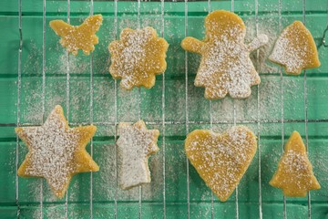 Directly above shot of powdered sugar on cookies over cooling
