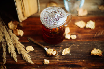 green circle in the scarf, the window with maple leaves and drops after rain in autumn / season when you need warm drinks