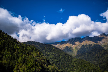 large dense mountain against a blue sky with clouds