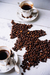 Shape of christmas tree made of coffee beans on wooden table. Top view, copy space. Winter holidays concept