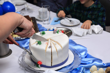 Tort urodzinowy dla małego chłopca i ciasta na stole, krojenie tortu. - obrazy, fototapety, plakaty
