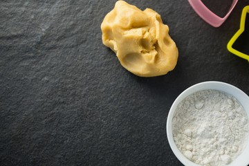 Obraz na płótnie Canvas High angle view of dough by flour in bowl