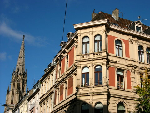 Prachtvolle Altbauten und Kirchturm der Herz Jesu Kirche im Herbst vor blauem Himmel im Sonnenschein in K&ouml;ln am Rhein in Nordrhein-Westfalen