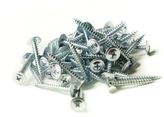 Tapping screws made of steel, metal screw, iron screw, chrome screw, screws as a background, wood screw. Isolated on white background.