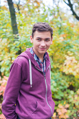 Portrait of a joyful teenage boy in an autumn forest