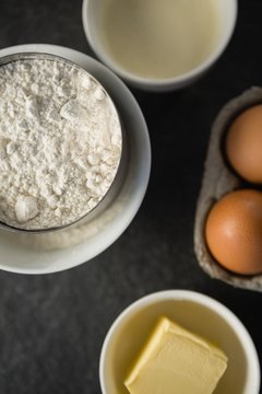 Overhead view of flour with butter and eggs