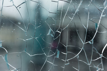 Broken glass with cracks with a blurred background of city streets