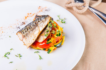 Close up grilling steak from fish with vegetable pillow served on the white plate. Restaurant...