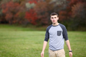 Portrait of a teenage boy posing with a serious face outdoors
