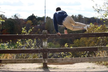 Delinquent teenager jumping a fence to trespass - obrazy, fototapety, plakaty