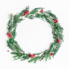 Fototapeta na wymiar Christmas composition. Wreath made of christmas tree branches and red berries on white background. Flat lay, top view, copy space, square