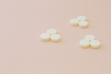 White set of pills on pink background