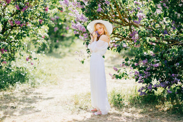 Young beautiful doll girl with angelic face in white expensive summer dress and haat with fields...